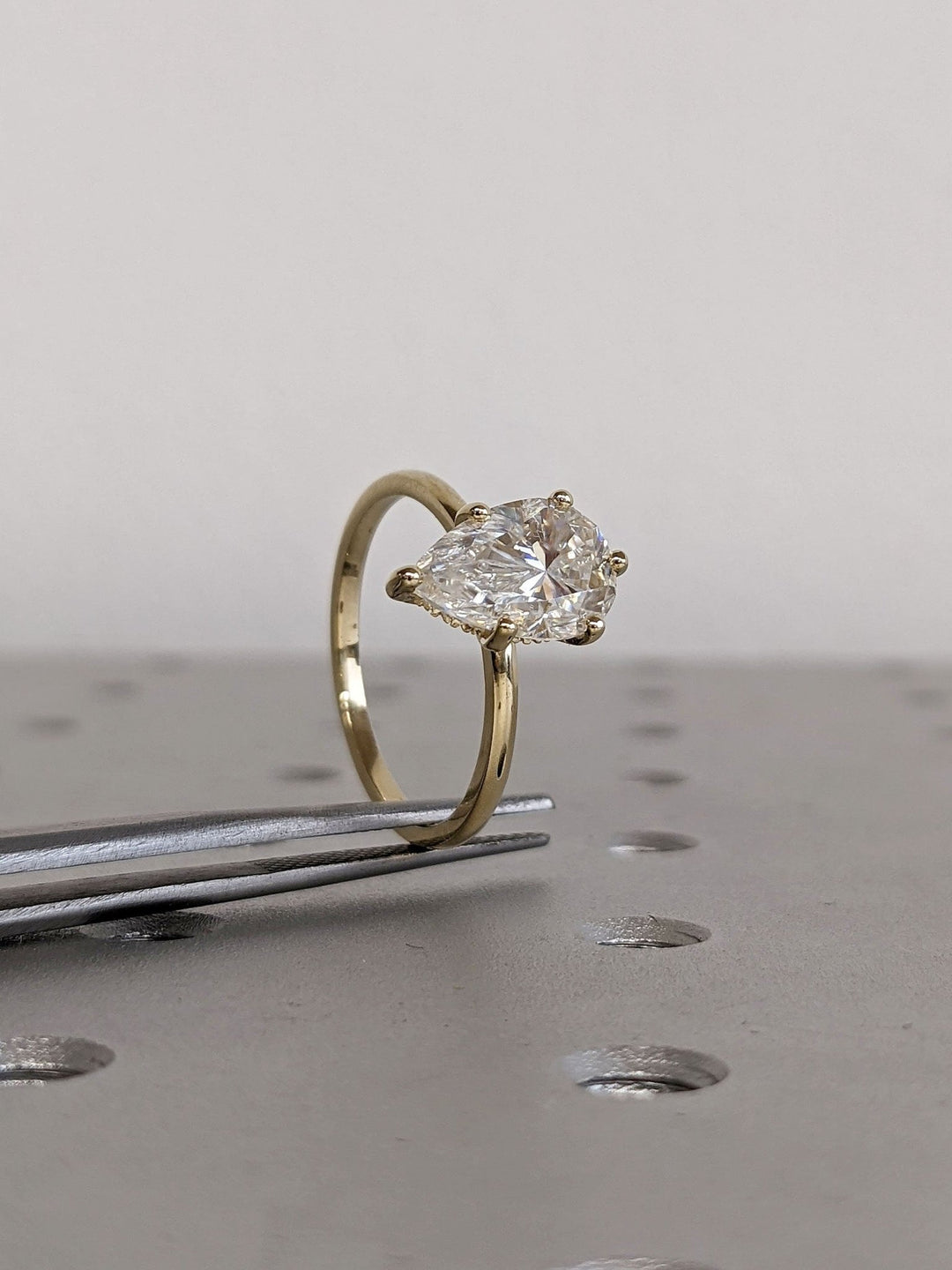 Pear cut engagement ring with hidden halo setting