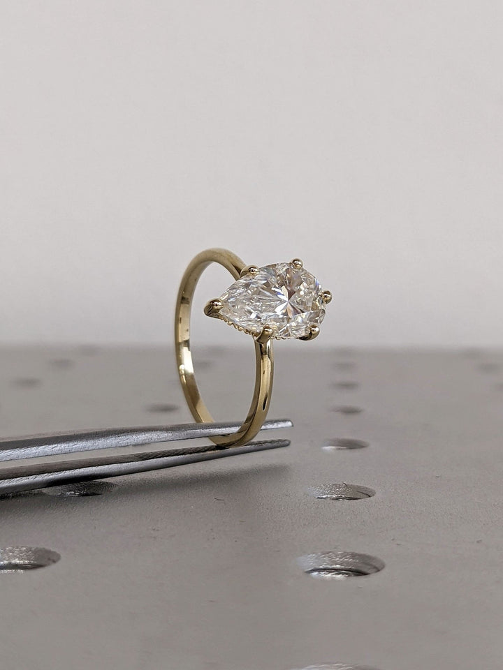 Pear cut engagement ring with hidden halo setting