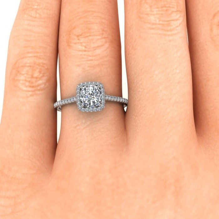 Round halo accent diamonds surrounding cushion cut center stone