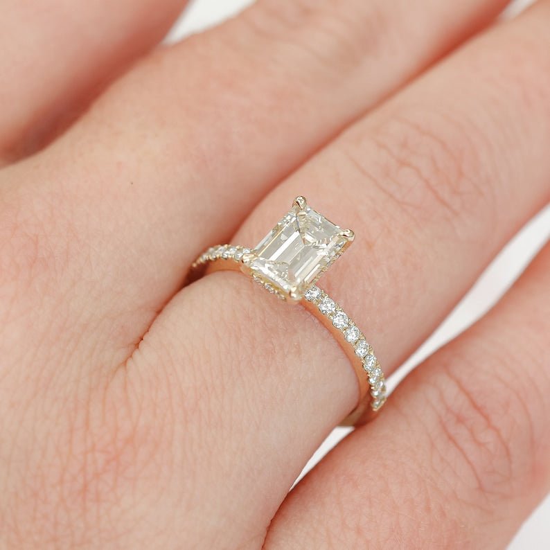 Emerald hidden halo engagement ring shown on hand for true-to-life sizing