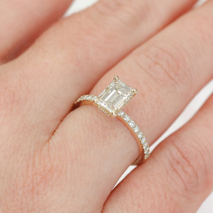 Emerald hidden halo engagement ring shown on hand for true-to-life sizing