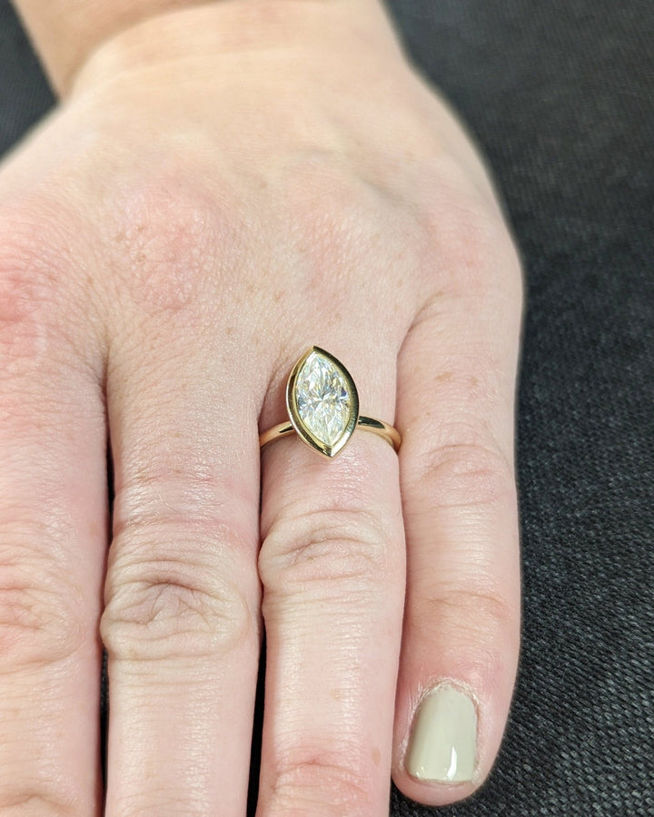 Elegant proposal ring with marquise cut bezel design