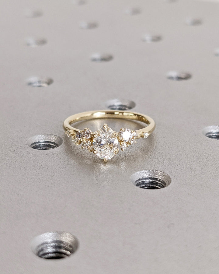 Sparkling oval cluster diamond ring with leaf motif accents