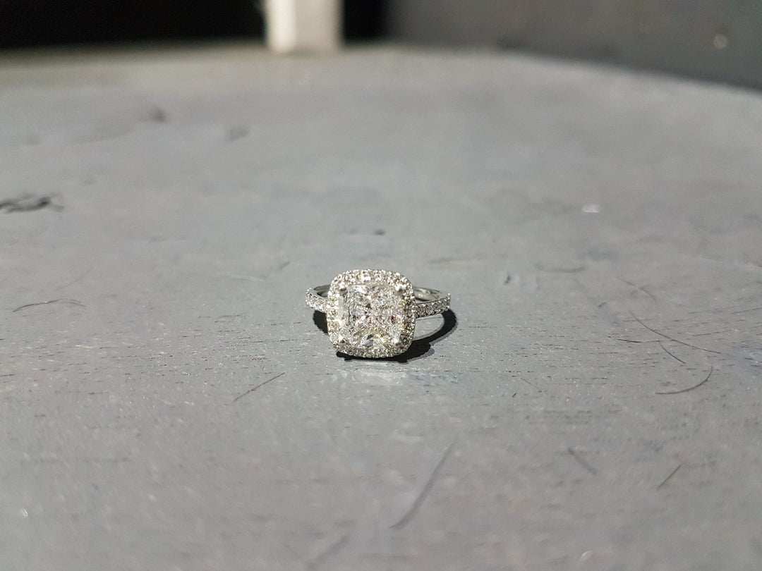 Modern halo engagement ring featuring cushion cut diamond