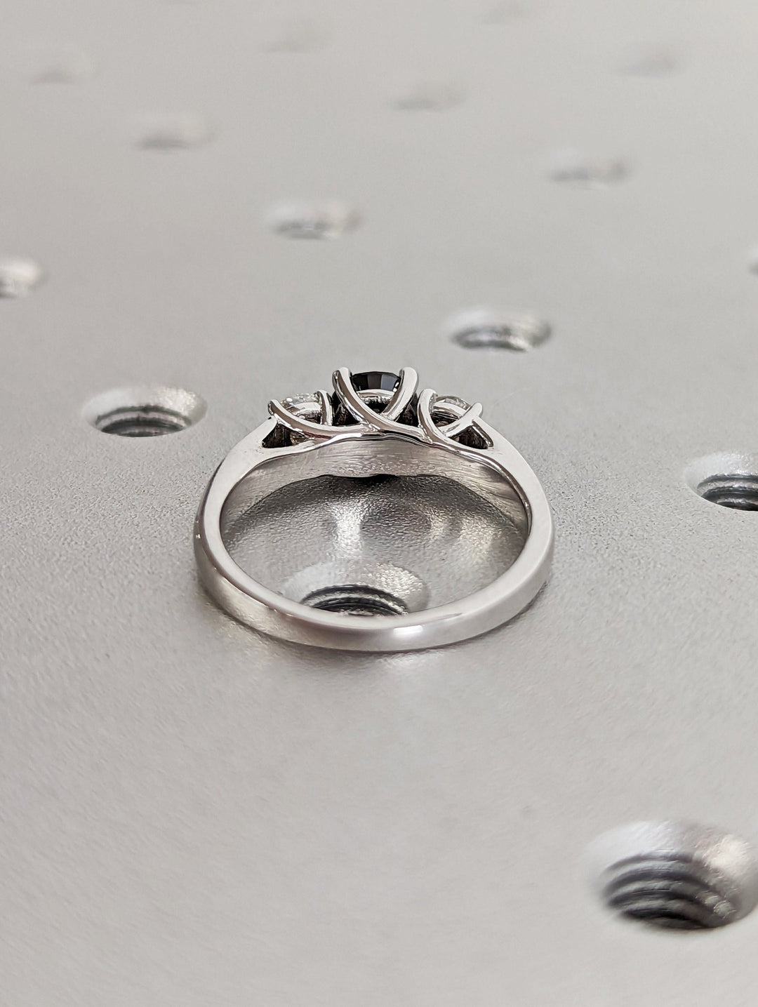 Sparkling diamond side stones with black round centerpiece