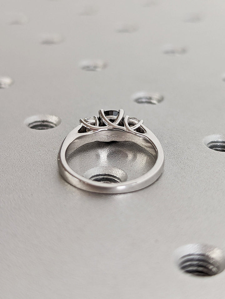 Sparkling diamond side stones with black round centerpiece